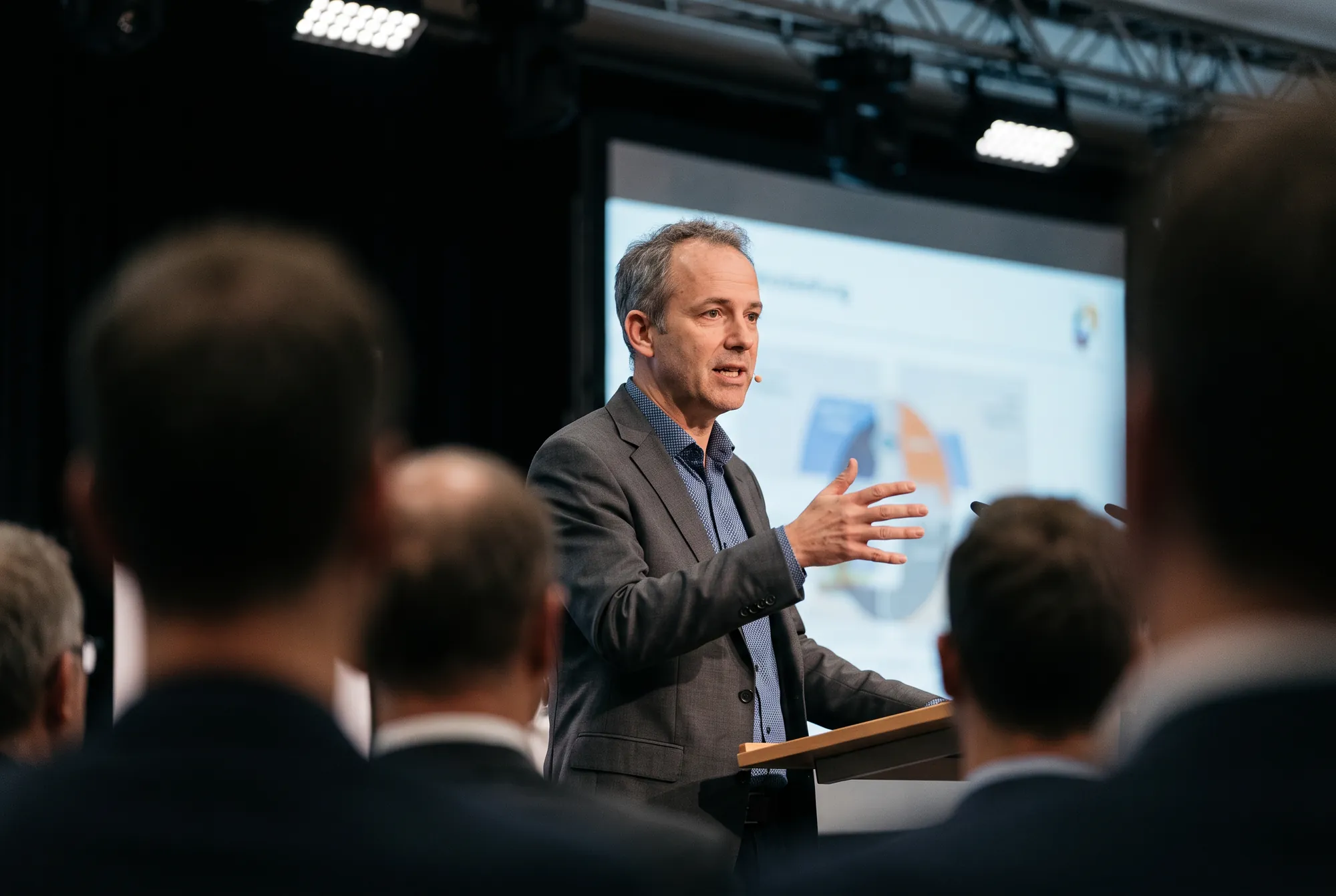 Speaker am Redepult, aus dem Publikum fotografiert