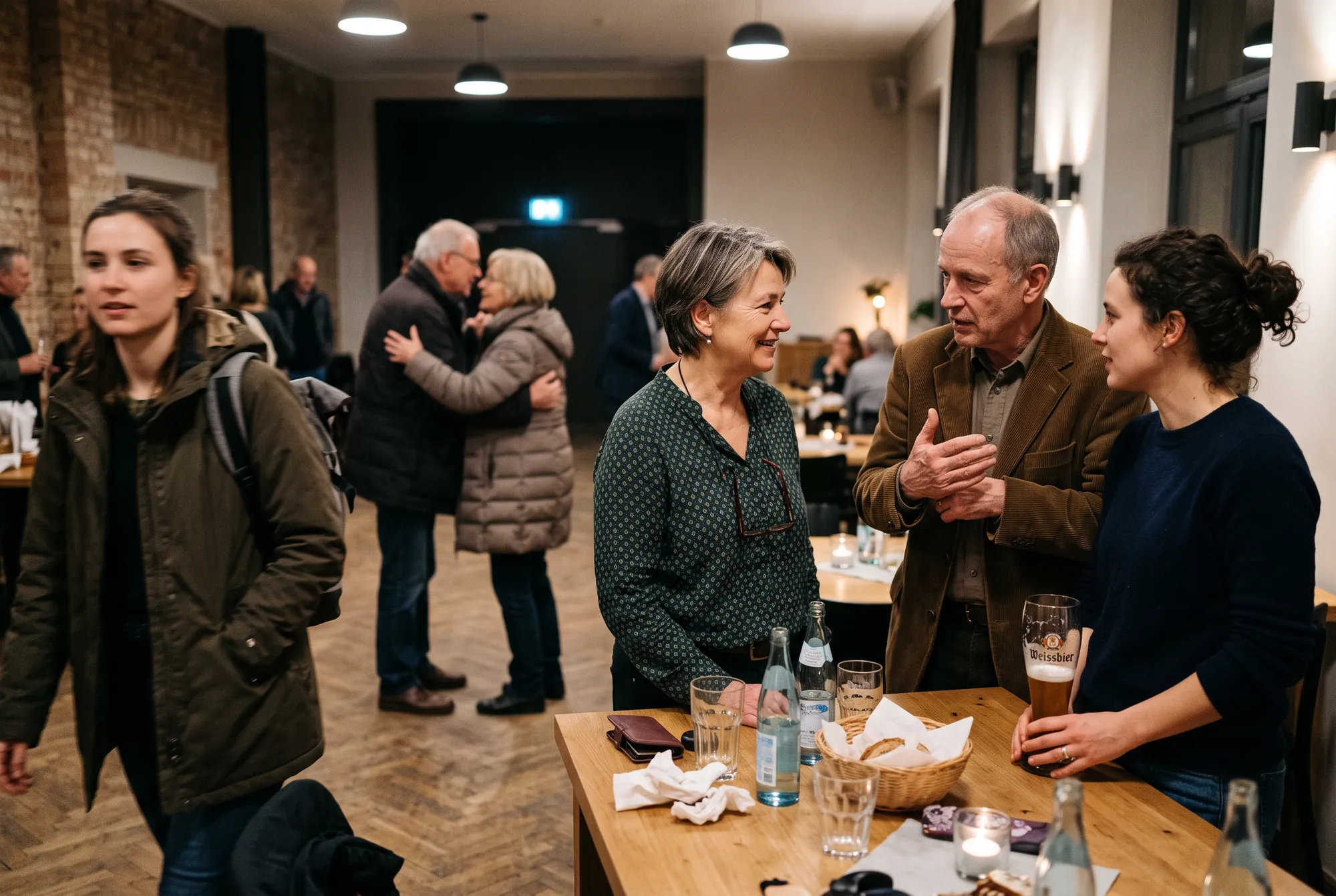 Gäste im Gespräch bei einer privaten Feier in Potsdam, warmes Licht
