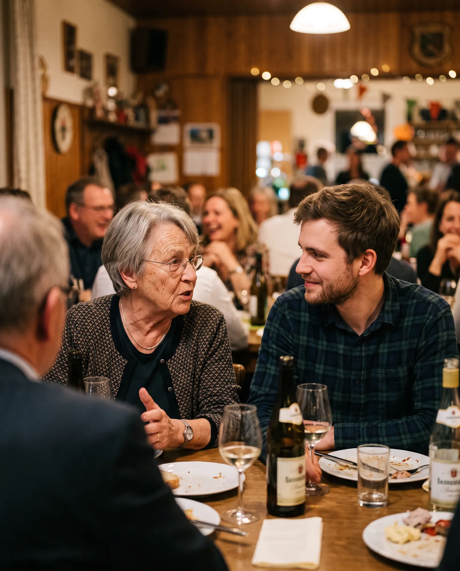 Älterer und jüngerer Gast im Gespräch bei einer Feier