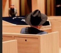 Veranstaltung in der Synagoge Potsdam, ein Gast mit Hut von hinten im Holzgestühl